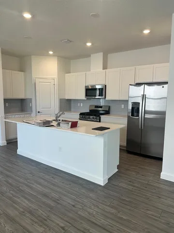 a kitchen with stainless steel appliances a refrigerator sink and cabinets