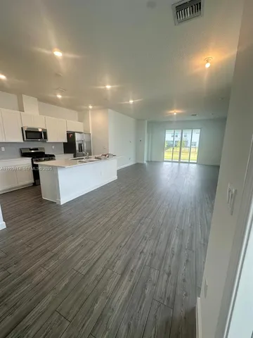 a view of kitchen with cabinets and wooden floor
