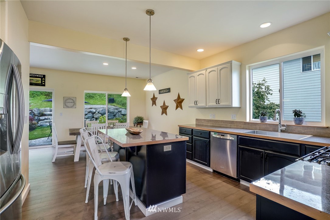 5910 Larimer Road, Unit A Everett, WA 98208 - Photo 11 of 24 a kitchen with stainless steel appliances granite countertop a sink a stove a dining table and chairs