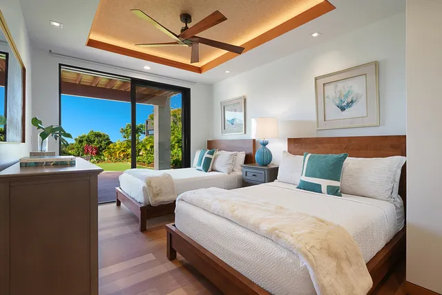 a bedroom with two beds and a large window