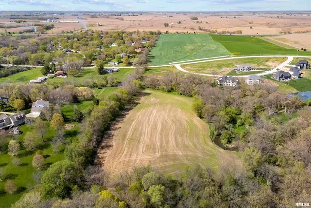 an aerial view of a houses with a yard and lake view