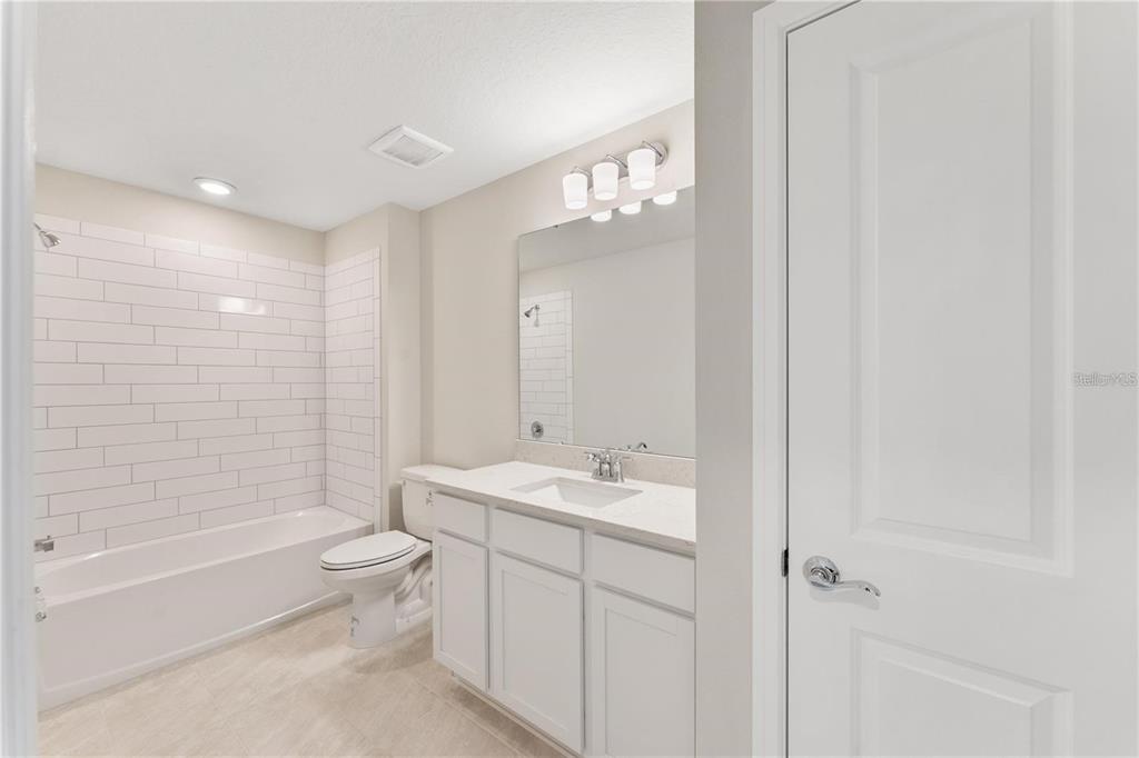 2326 Vision Street Davenport, FL 33896 - Photo 12 of 29 a bathroom with a toilet a sink a mirror a bathtub and shower