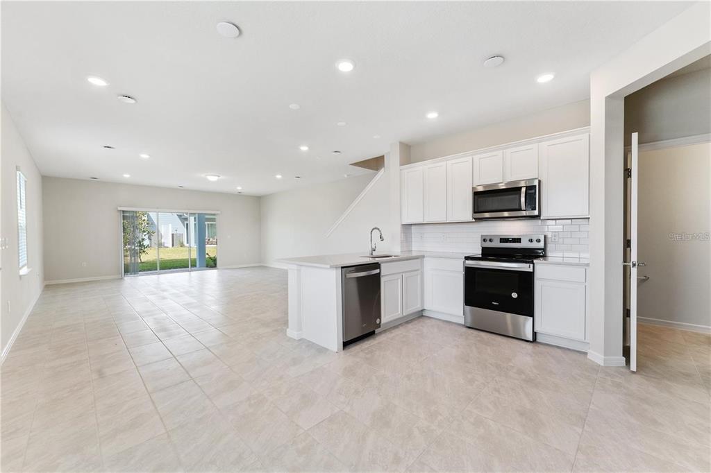 2326 Vision Street Davenport, FL 33896 - Photo 3 of 29 a kitchen with a refrigerator and a stove top oven