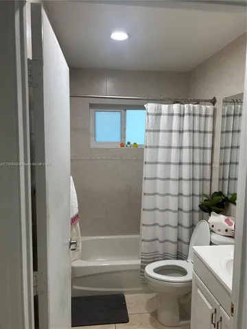 a bathroom with a granite countertop toilet and a sink