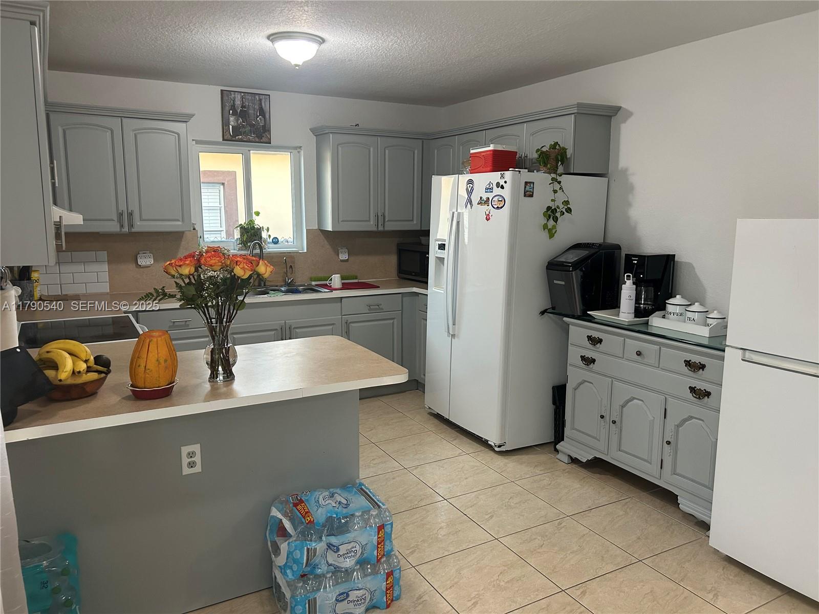 1446 Northwest 61st Street Miami, FL 33142 - Photo 27 of 54 a kitchen with refrigerator and cabinets