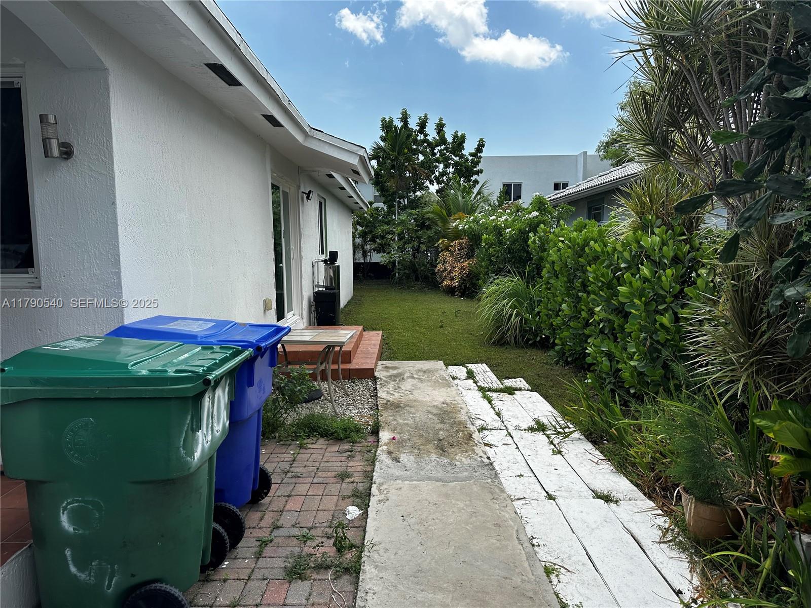 1446 Northwest 61st Street Miami, FL 33142 - Photo 32 of 54 a view of a patio with table and chairs potted plants with wooden floor