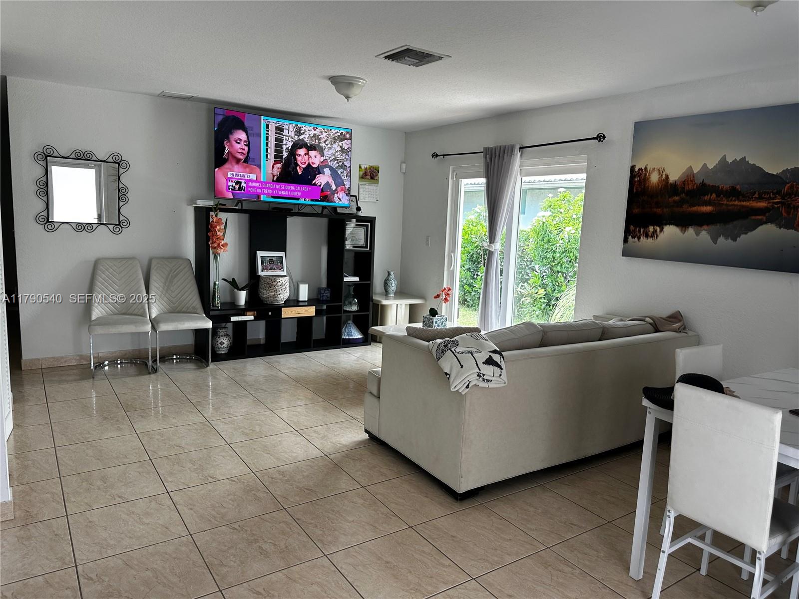 1446 Northwest 61st Street Miami, FL 33142 - Photo 39 of 54 a living room with furniture and a flat screen tv