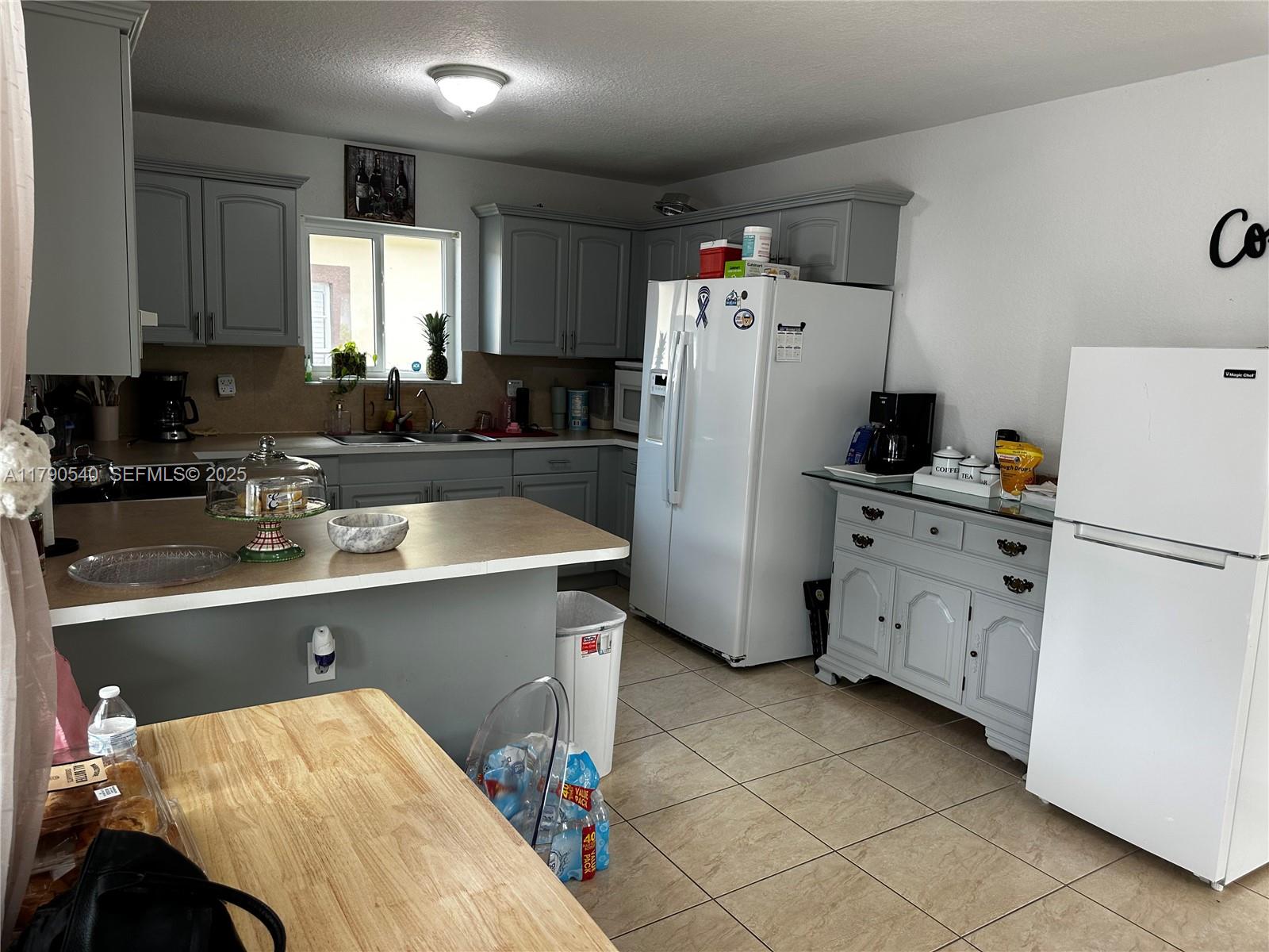 1446 Northwest 61st Street Miami, FL 33142 - Photo 40 of 54 a kitchen with refrigerator and cabinets