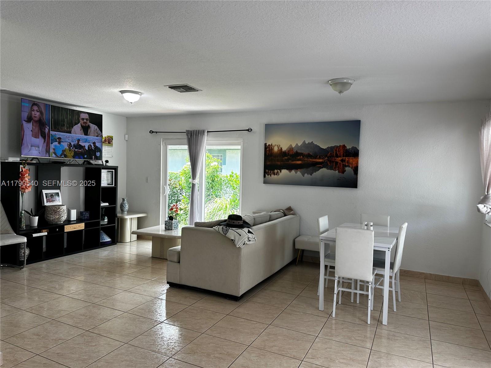 1446 Northwest 61st Street Miami, FL 33142 - Photo 43 of 54 a living room with furniture and a flat screen tv