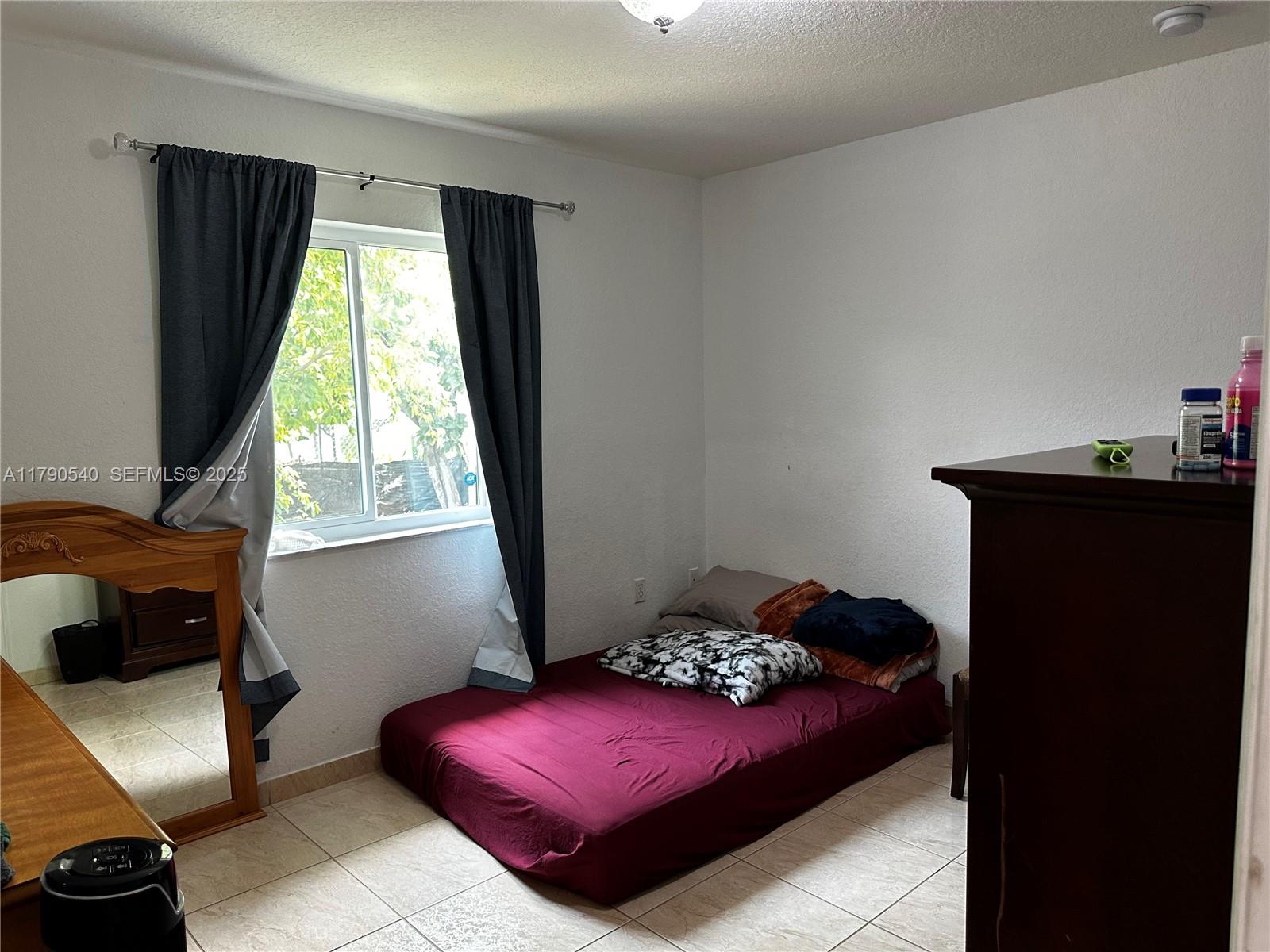1446 Northwest 61st Street Miami, FL 33142 - Photo 53 of 54 a bedroom with a bed and a window