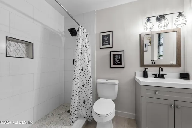 a view of a yard with plants and large trees