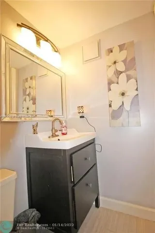 a bathroom with a granite countertop sink mirror vanity and toilet