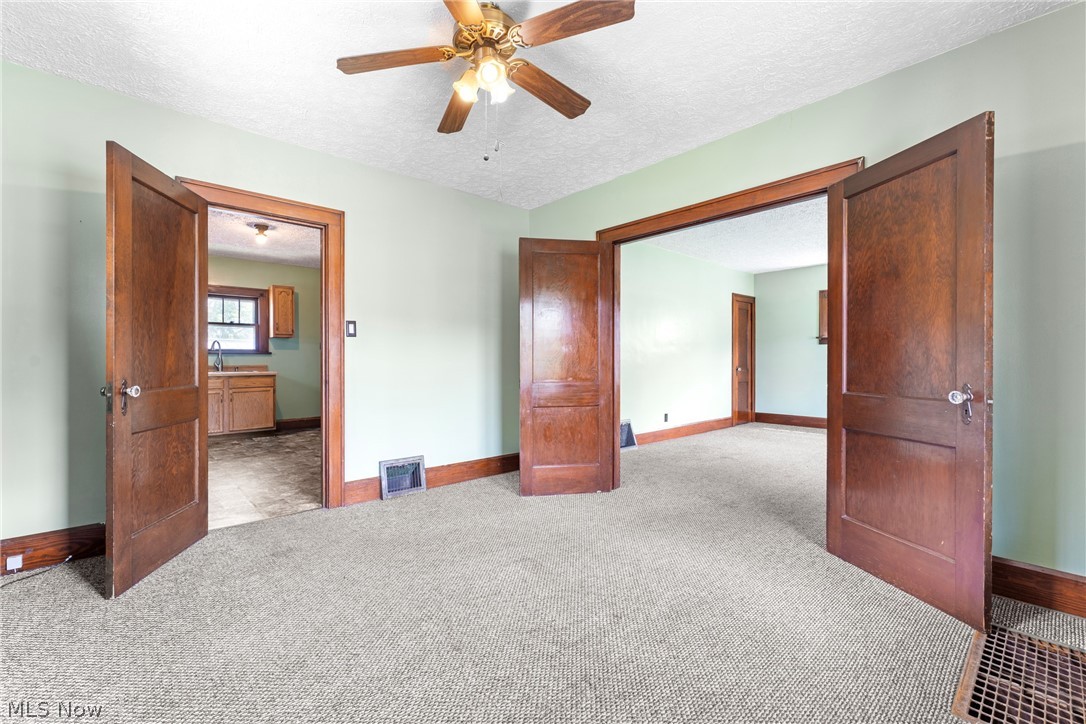 16 South State Street Rittman, OH 44270 - Photo 12 of 27 Spare room with a textured ceiling, carpet, and ceiling fan