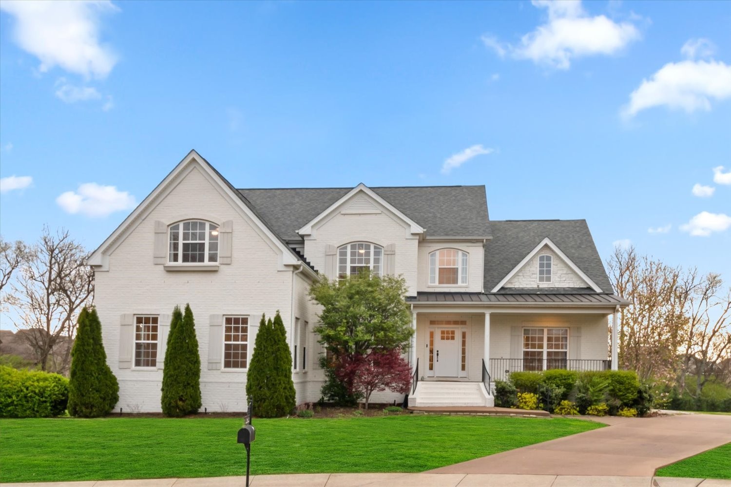 a front view of a house with a yard and trees