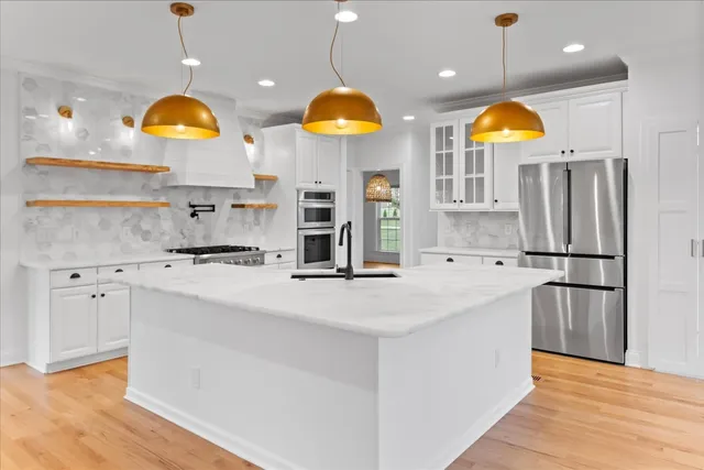 a kitchen with stainless steel appliances granite countertop a refrigerator and a sink