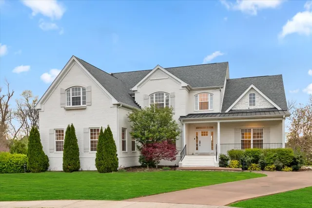 a front view of a house with a yard and trees