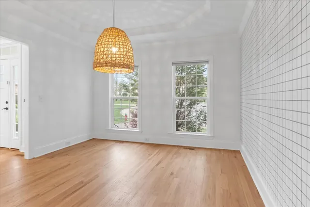a view of empty room with wooden floor and fireplace