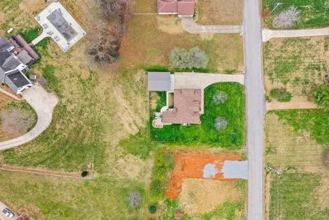an aerial view of a house with garden space and ocean view