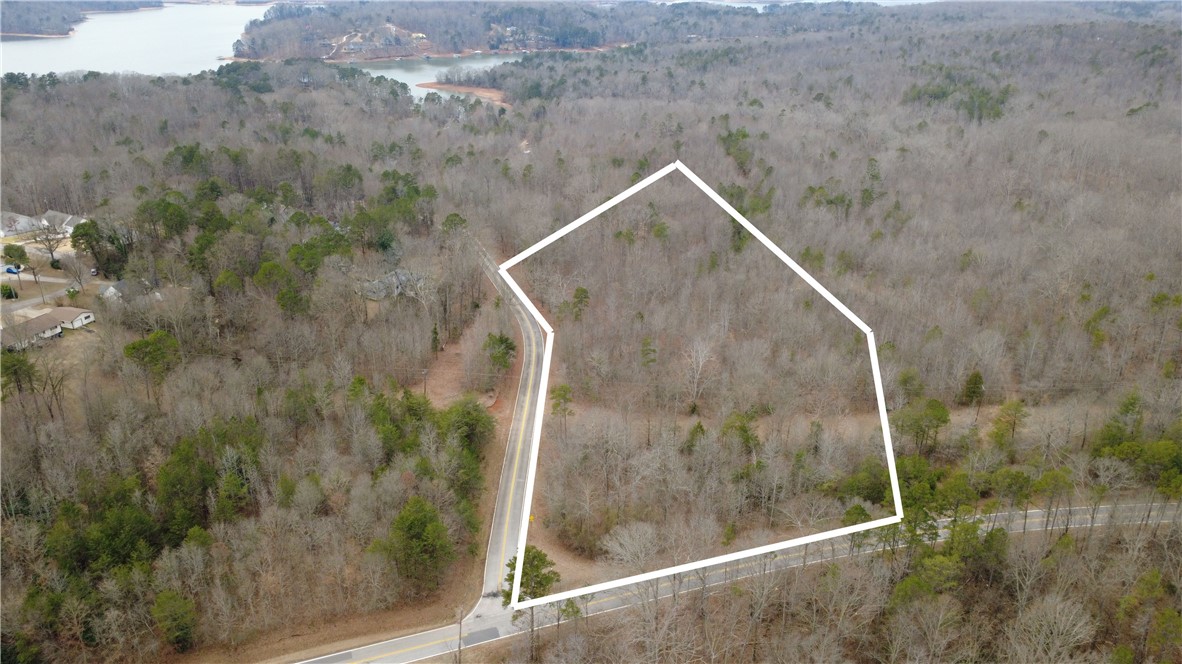 This expansive lot features mature trees and direct road access, offering a serene backdrop for future endeavors.