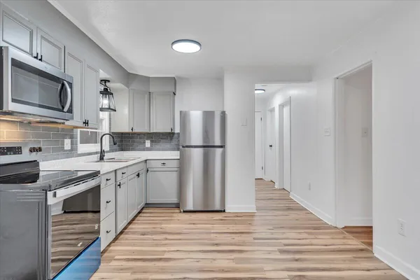 a kitchen with stainless steel appliances granite countertop a refrigerator stove microwave and sink