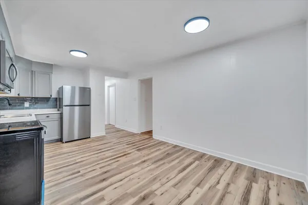 a view of kitchen with wooden floor and electronic appliances