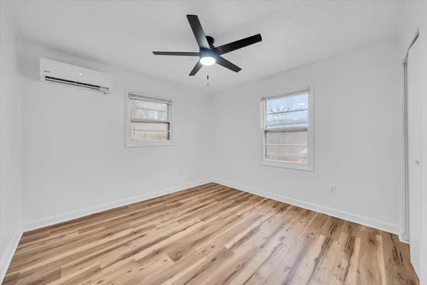 a view of empty room with wooden floor and ceiling fan