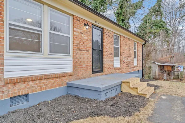 a view of house with backyard and sitting area