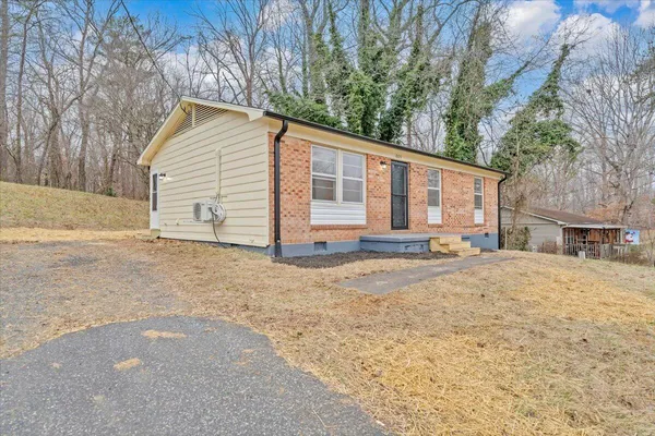 a view of a house with backyard and trees