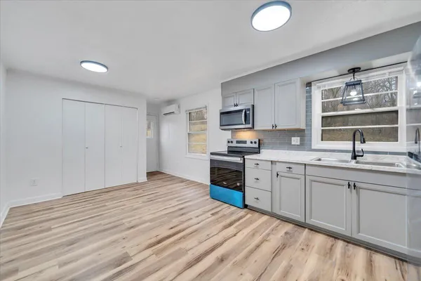 a kitchen with granite countertop a sink cabinets stainless steel appliances and a window