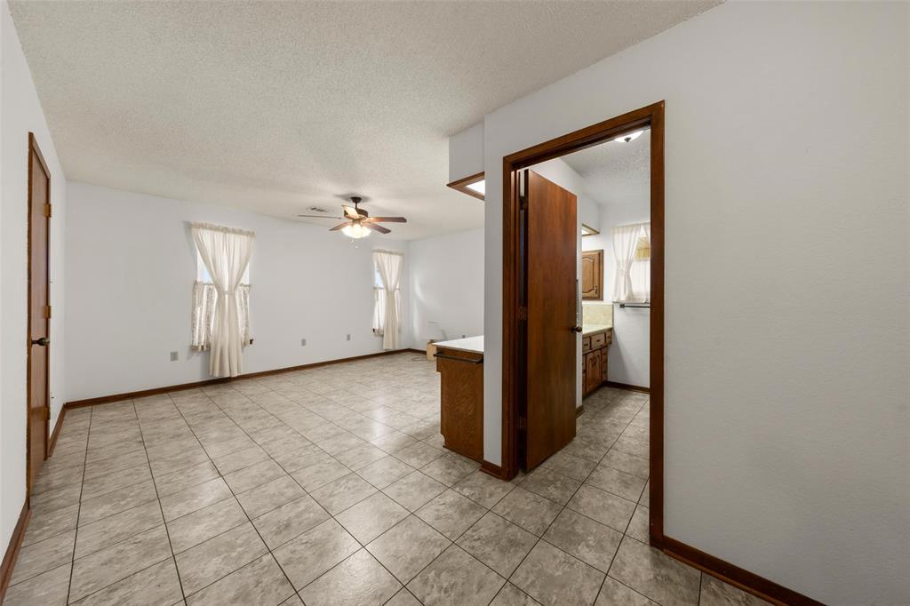 4121 Tokio Road West, TX 76691 - Photo 12 of 21 Empty room featuring ceiling fan, a textured ceiling, and light tile patterned floors