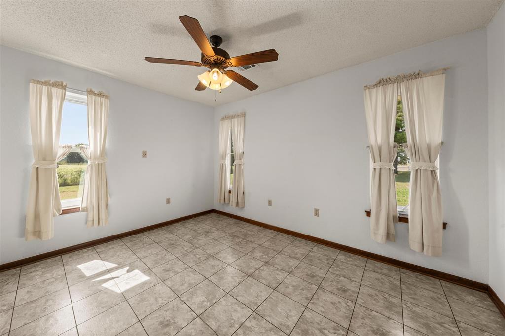 4121 Tokio Road West, TX 76691 - Photo 15 of 21 Spare room with a textured ceiling, ceiling fan, and light tile patterned floors