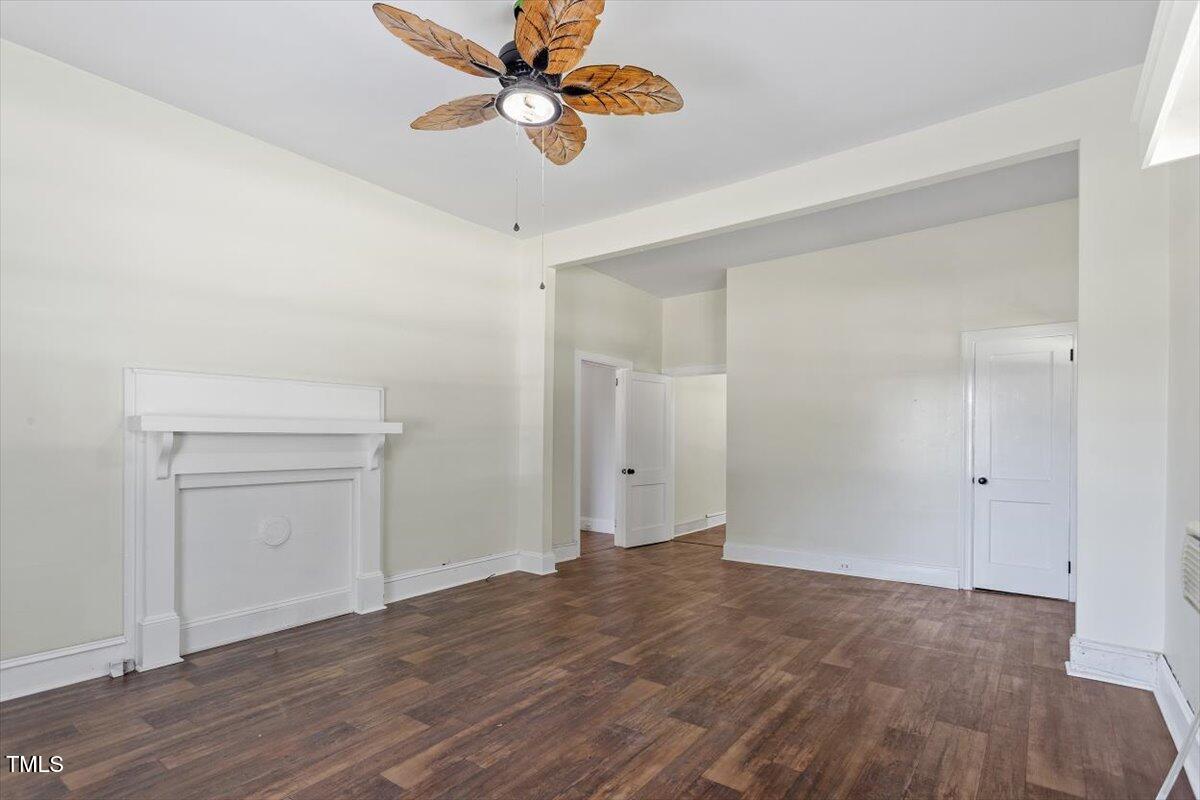 123 King Road Warrenton, NC 27589 - Photo 3 of 24 an empty room with a ceiling fan and wooden floor
