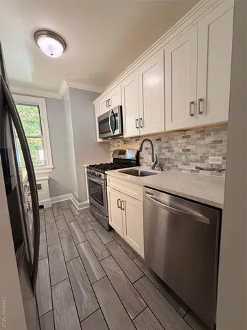 a kitchen with stainless steel appliances granite countertop a sink stove and cabinets