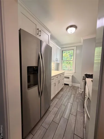 a kitchen with stainless steel appliances a refrigerator and a window