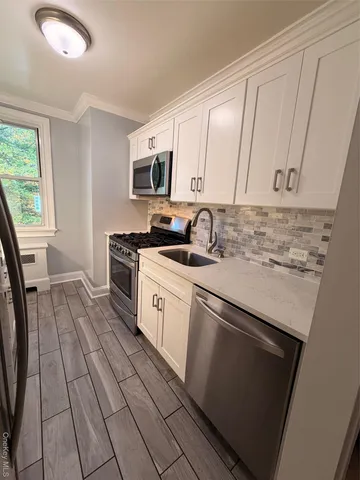a kitchen with stainless steel appliances a sink stove and cabinets