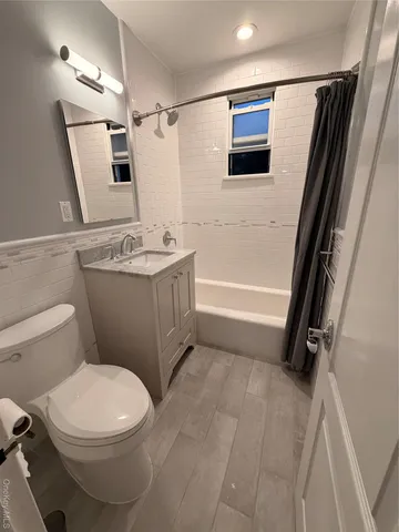 a bathroom with a sink a toilet a mirror and shower