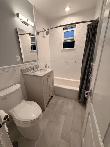 a bathroom with a sink a toilet a mirror and shower