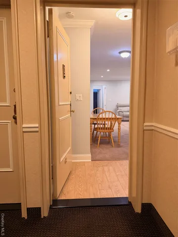 a view of a hallway and dining room with furniture