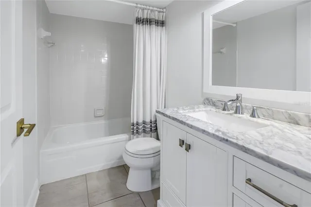 a bathroom with a granite countertop sink a toilet and bathtub