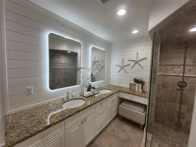 a bathroom with a granite countertop sink mirror and vanity