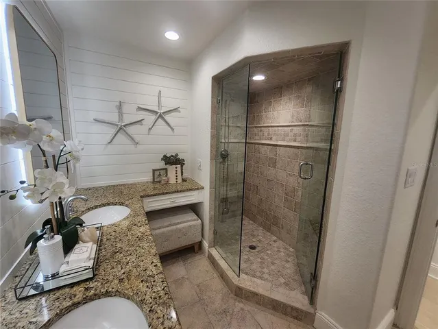 a bathroom with a granite countertop shower a sink and toilet