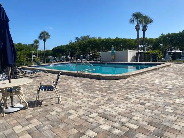 a view of a swimming pool with a chair and tables in the patio