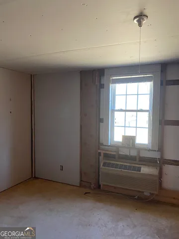 a view of a hallway with wooden floor and windows