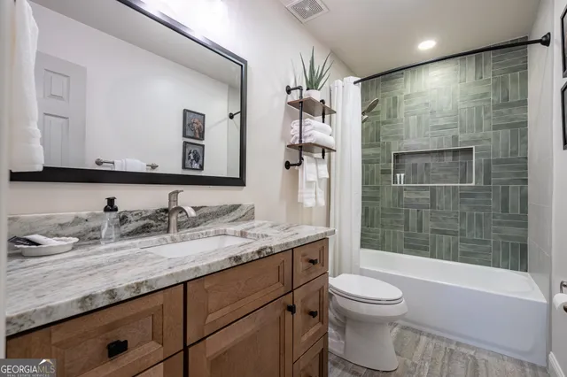 a bathroom with a granite countertop sink toilet and shower