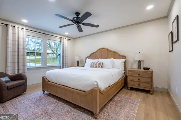 a bedroom with a bed a couch and a ceiling fan