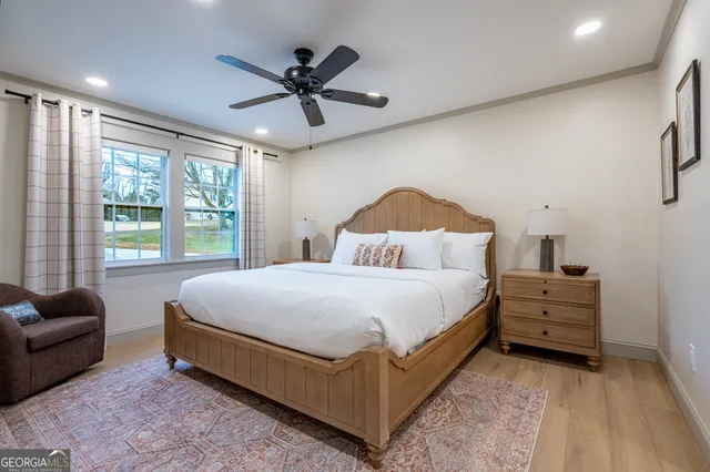 a bedroom with a bed a couch and a ceiling fan