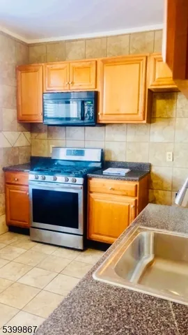 a kitchen with a sink a counter and a stove top oven