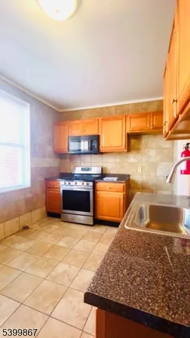 a kitchen with stainless steel appliances granite countertop a sink stove and cabinets