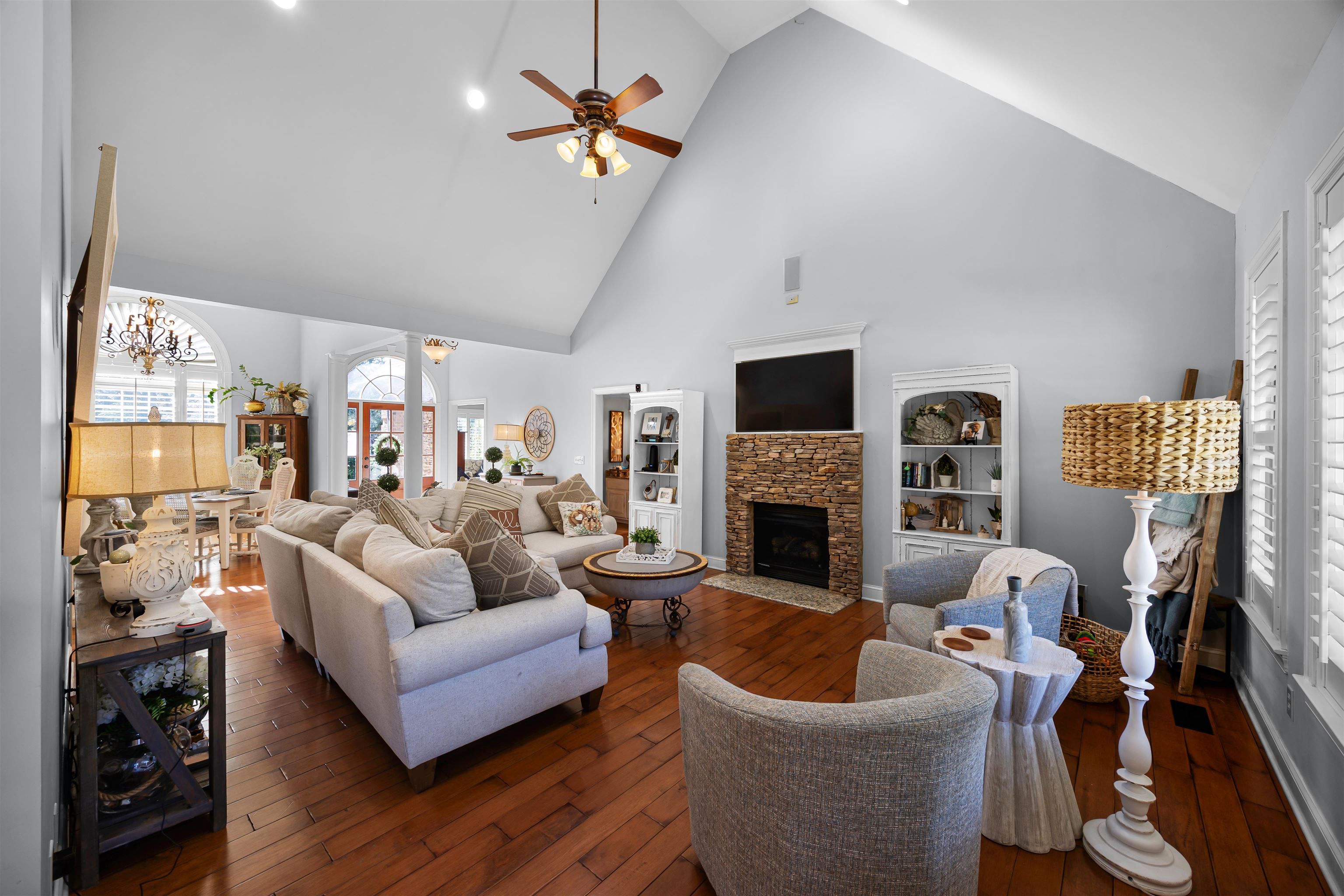 140 Legends Drive Counce, TN 38326 - Photo 6 of 30 Living area featuring high vaulted ceiling, dark wood-style floors, a fireplace, a ceiling fan, and a chandelier