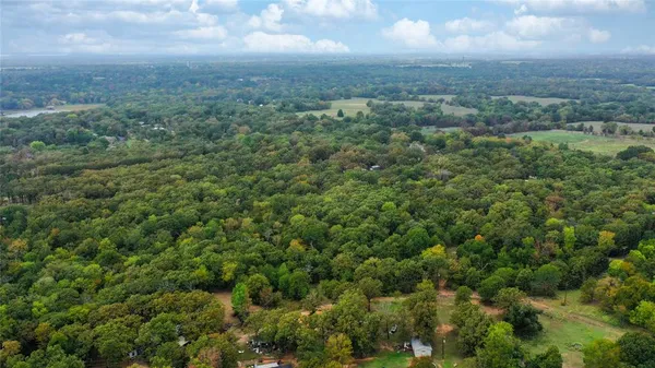 an aerial view of residential house with outdoor space and trees around